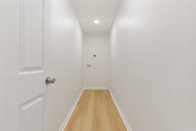 hall with light wood-style floors and baseboards