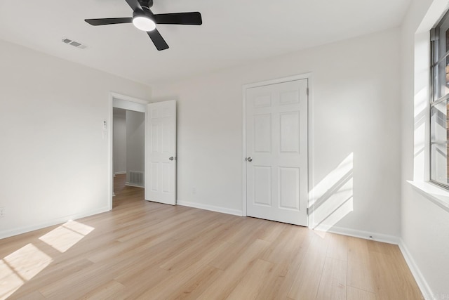 unfurnished bedroom with light wood-type flooring, visible vents, and baseboards