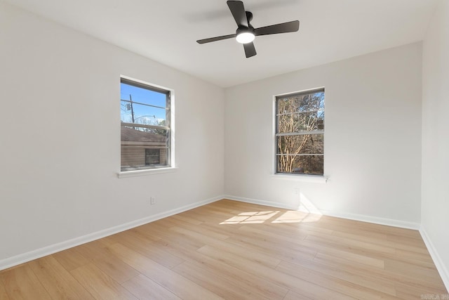 empty room featuring light wood finished floors, baseboards, and a ceiling fan