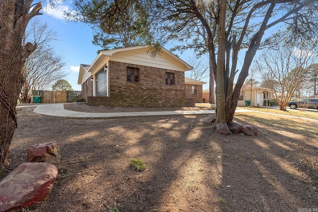 view of home's exterior with brick siding and fence