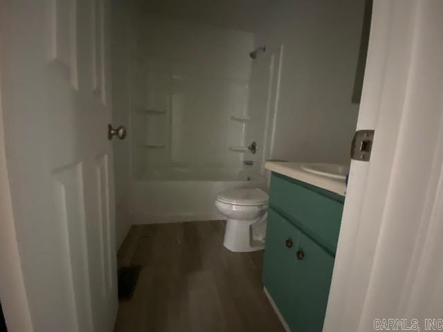 full bathroom featuring toilet, bathtub / shower combination, wood finished floors, and vanity