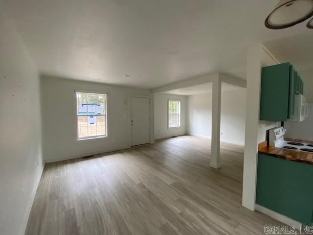 unfurnished living room with light wood-style flooring and baseboards