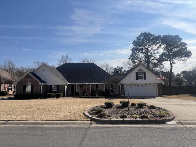 view of front of home featuring a garage, brick siding, concrete driveway, and fence