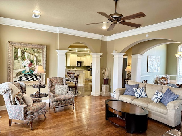 living room with ornamental molding, hardwood / wood-style flooring, decorative columns, and visible vents