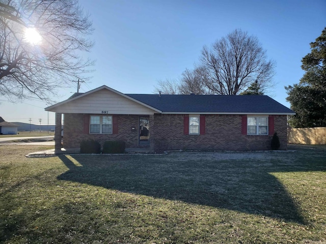 ranch-style house featuring a front yard, brick siding, and fence