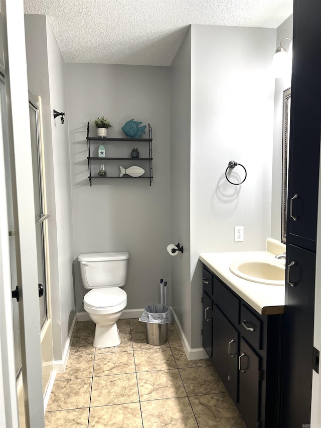 bathroom featuring toilet, a shower with shower door, a textured ceiling, vanity, and baseboards