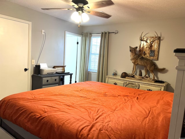 bedroom with ceiling fan and a textured ceiling