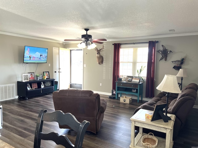 living room with dark wood-style flooring, visible vents, ornamental molding, a textured ceiling, and baseboards