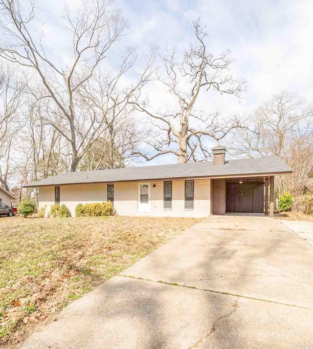 ranch-style house featuring driveway, a chimney, and an attached carport