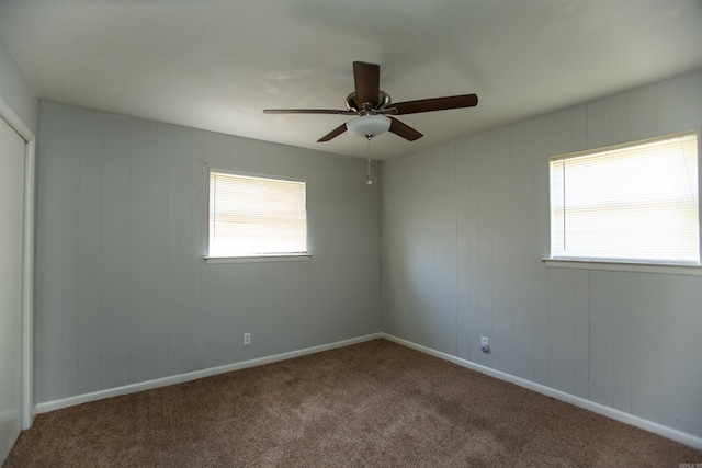 carpeted spare room with baseboards and a wealth of natural light