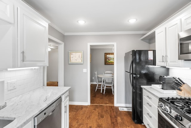 kitchen with stainless steel appliances, dark wood-type flooring, white cabinetry, and light stone counters