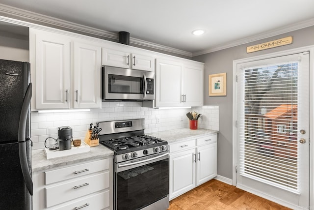 kitchen featuring crown molding, light wood finished floors, decorative backsplash, appliances with stainless steel finishes, and white cabinets