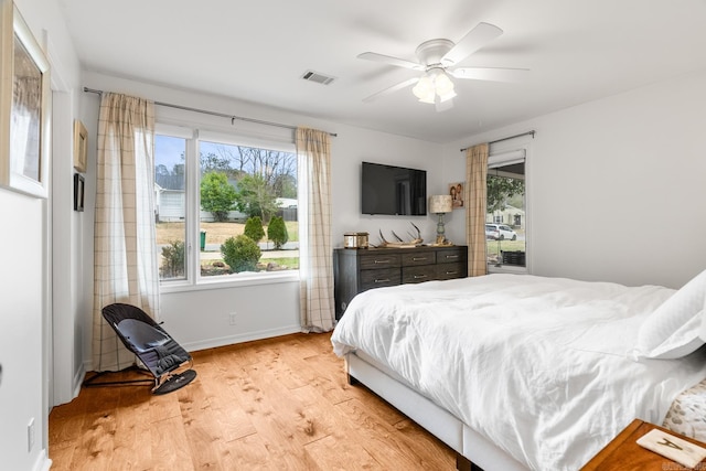 bedroom with visible vents, ceiling fan, baseboards, and wood finished floors