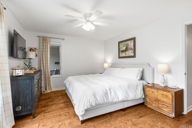 bedroom featuring light wood-style floors, baseboards, and a ceiling fan