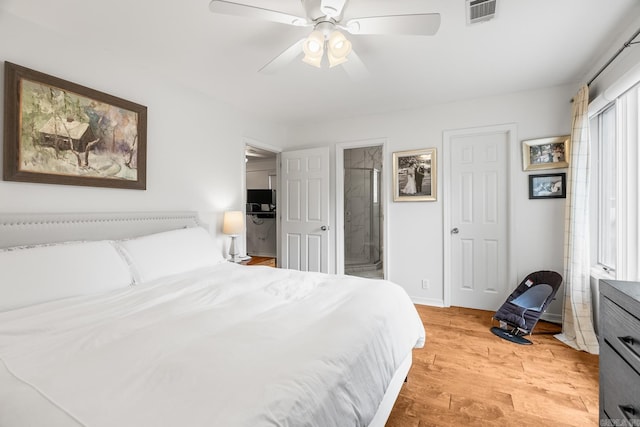 bedroom with ceiling fan, light wood finished floors, visible vents, and ensuite bathroom