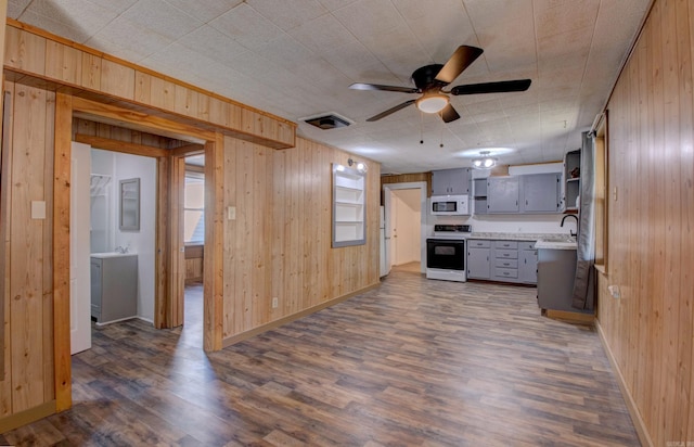 1612 Ridge Rd, El Paso, AR 72045 - kitchen featuring electric range oven, white microwave, dark wood-type flooring, gray cabinetry, and wood walls