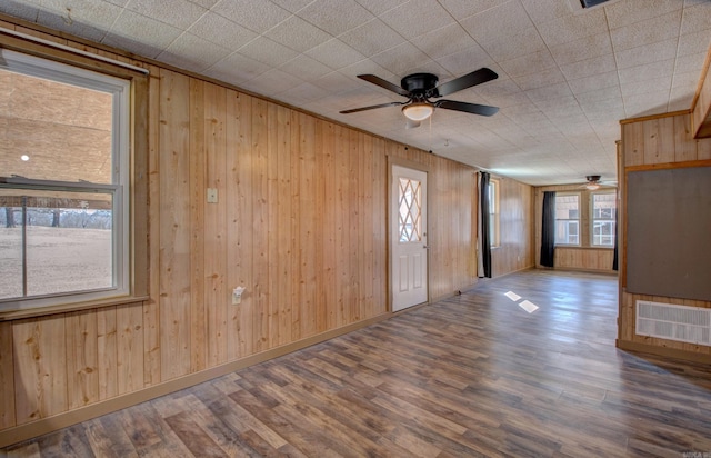 1612 Ridge Rd, El Paso, AR 72045 - spare room featuring wooden walls, baseboards, visible vents, a ceiling fan, and wood finished floors