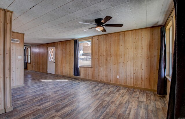 1612 Ridge Rd, El Paso, AR 72045 - empty room featuring baseboards, wooden walls, visible vents, and wood finished floors