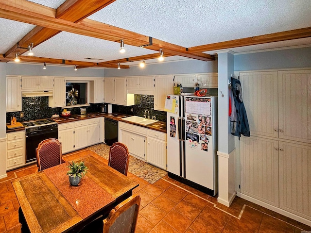 kitchen with under cabinet range hood, a sink, beam ceiling, black appliances, and dark countertops