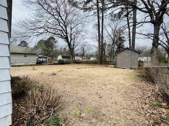 view of yard with an outbuilding, fence, and a storage unit