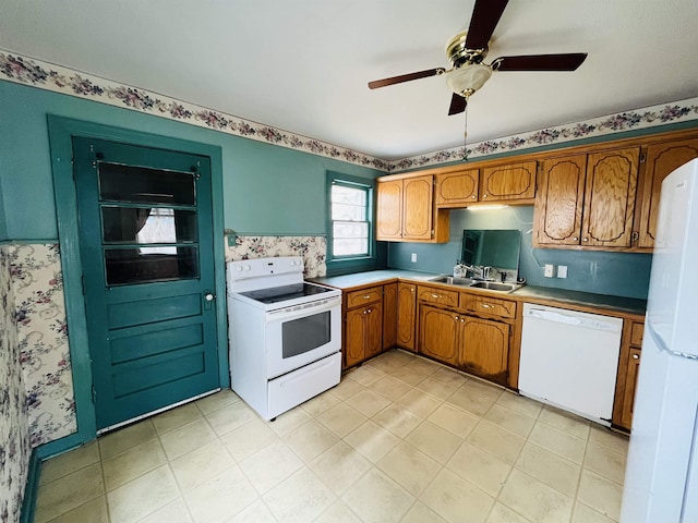 kitchen with white appliances, a ceiling fan, brown cabinets, and a sink