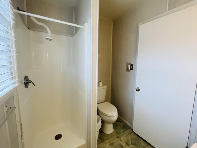 full bath featuring a stall shower and toilet