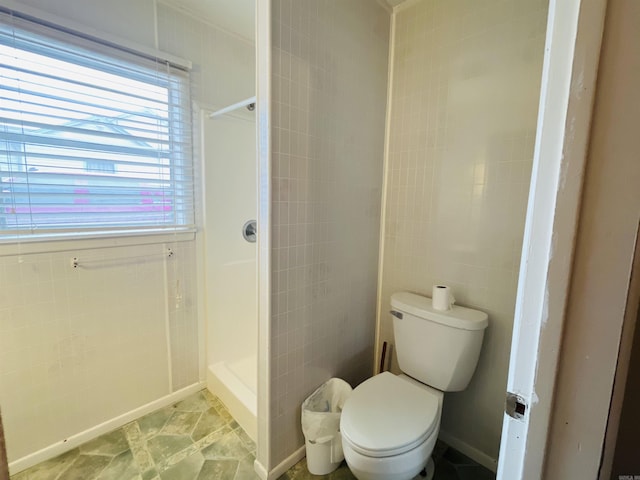 full bath with toilet, a shower stall, and tile walls