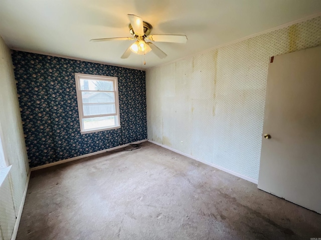 carpeted spare room featuring ceiling fan, baseboards, and wallpapered walls