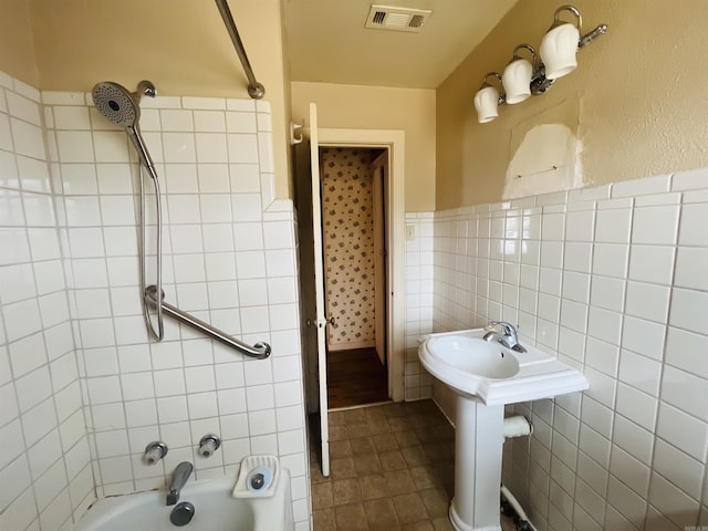 full bath with visible vents, a wainscoted wall, tile patterned flooring, shower / washtub combination, and tile walls