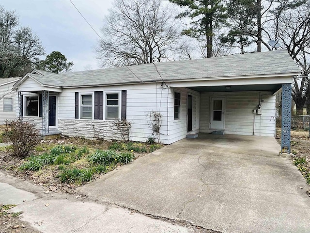 single story home featuring driveway, stone siding, and an attached carport