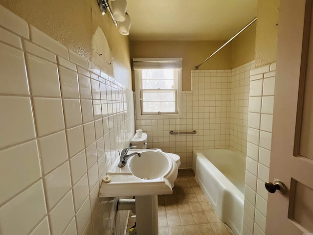 bathroom featuring tile walls, toilet, tile patterned flooring, shower / bathtub combination, and a sink