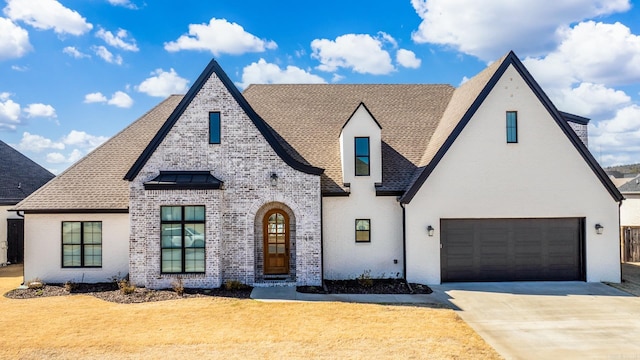 view of front of property featuring an attached garage, a front lawn, concrete driveway, and brick siding