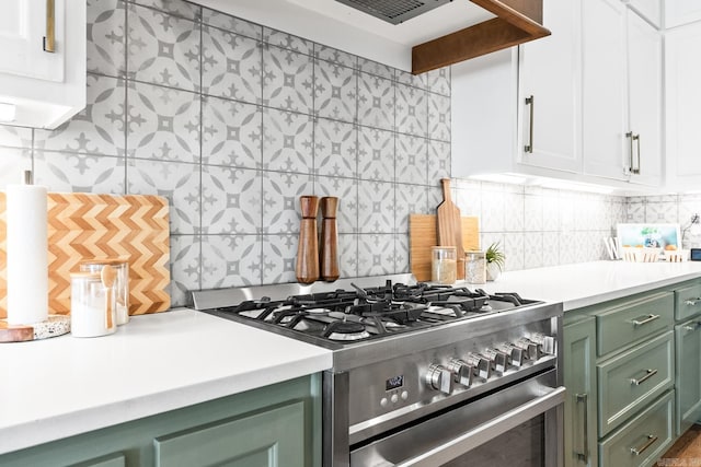 kitchen featuring green cabinets, light countertops, tasteful backsplash, and stainless steel gas stove