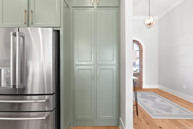 kitchen with light wood finished floors, arched walkways, green cabinetry, and high end fridge