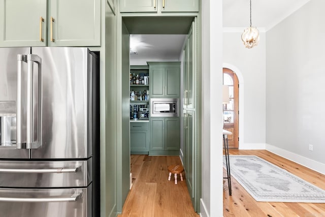 kitchen featuring arched walkways, light wood-style flooring, appliances with stainless steel finishes, open shelves, and green cabinetry