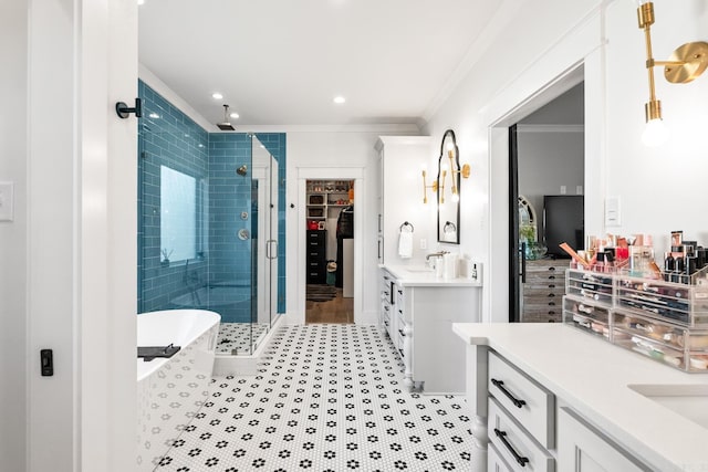 bathroom with a soaking tub, a spacious closet, ornamental molding, a shower stall, and vanity