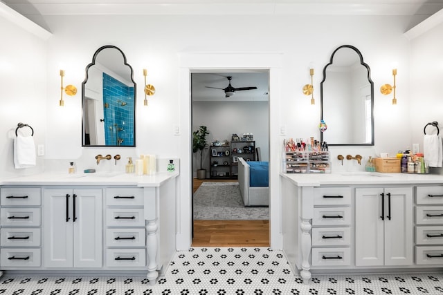 bathroom featuring ceiling fan, two vanities, and a sink