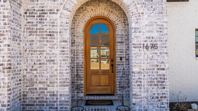 doorway to property with brick siding