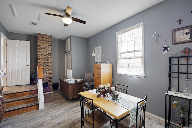 dining room featuring attic access, visible vents, baseboards, ceiling fan, and light wood-type flooring