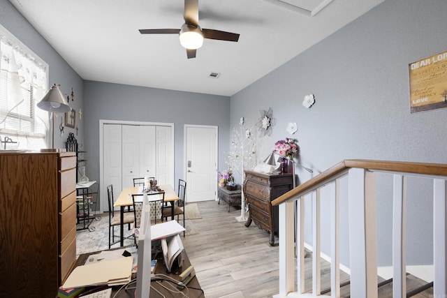 office with a ceiling fan, light wood-type flooring, and visible vents