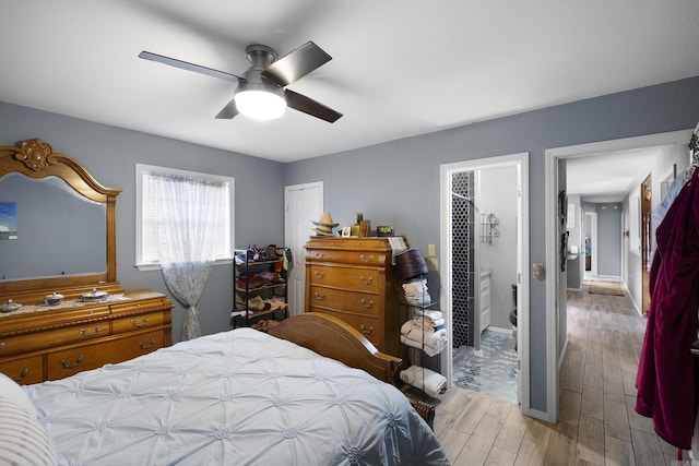 bedroom featuring wood finished floors, a ceiling fan, and connected bathroom