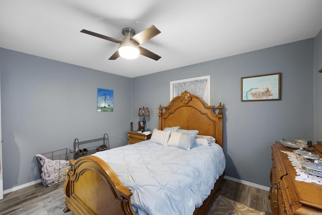 bedroom featuring ceiling fan, baseboards, and wood finished floors