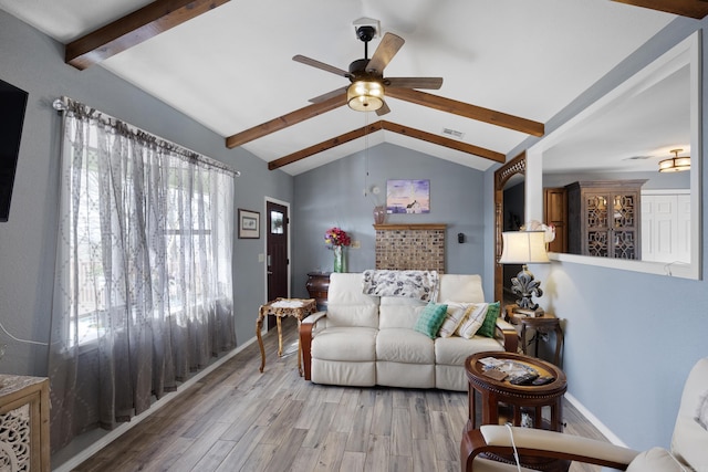 living area with baseboards, visible vents, lofted ceiling with beams, ceiling fan, and wood finished floors