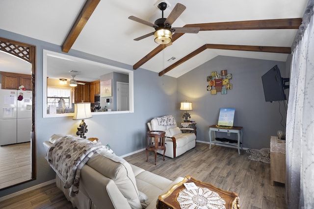 living area featuring baseboards, visible vents, lofted ceiling with beams, ceiling fan, and wood finished floors