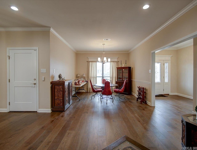 dining space featuring hardwood / wood-style flooring, baseboards, ornamental molding, and a chandelier