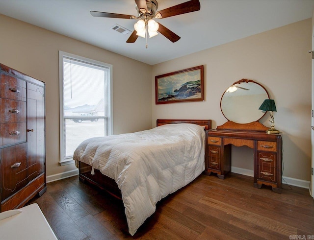 bedroom with a ceiling fan, baseboards, visible vents, and wood finished floors