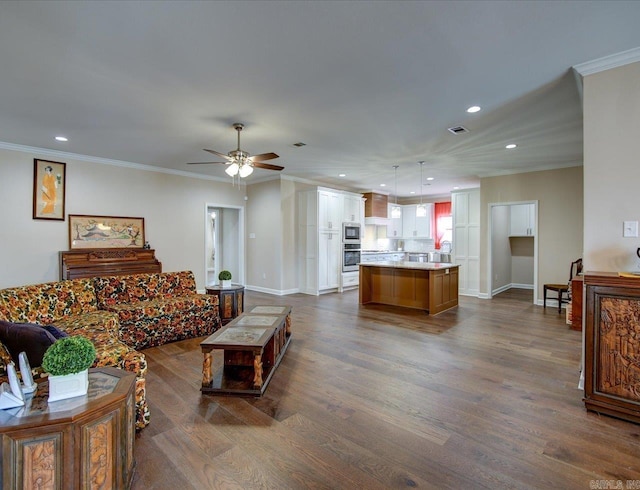 living area with baseboards, ornamental molding, dark wood finished floors, and recessed lighting