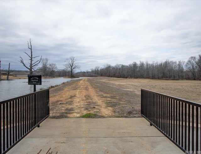 view of street with a water view and a gated entry