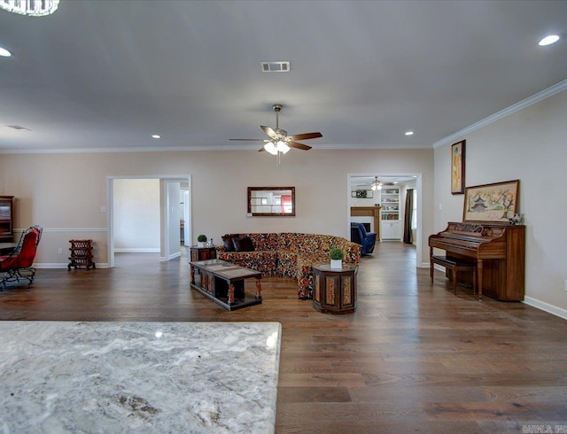 living room with a fireplace, recessed lighting, visible vents, ornamental molding, and wood finished floors