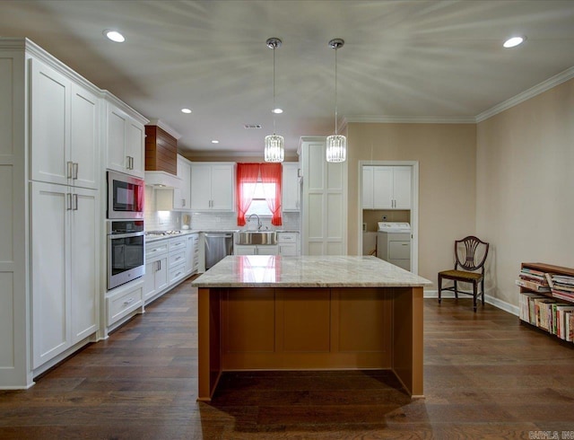 kitchen featuring stainless steel appliances, ornamental molding, a kitchen island, and dark wood finished floors